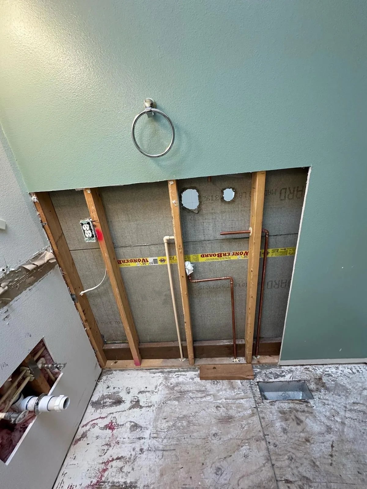 Copper supply lines run through open wall framing during a repipe