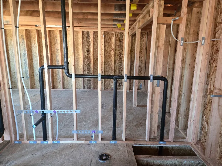 New construction rough-in with ABS drain, vent and PEX lines through wall framing
