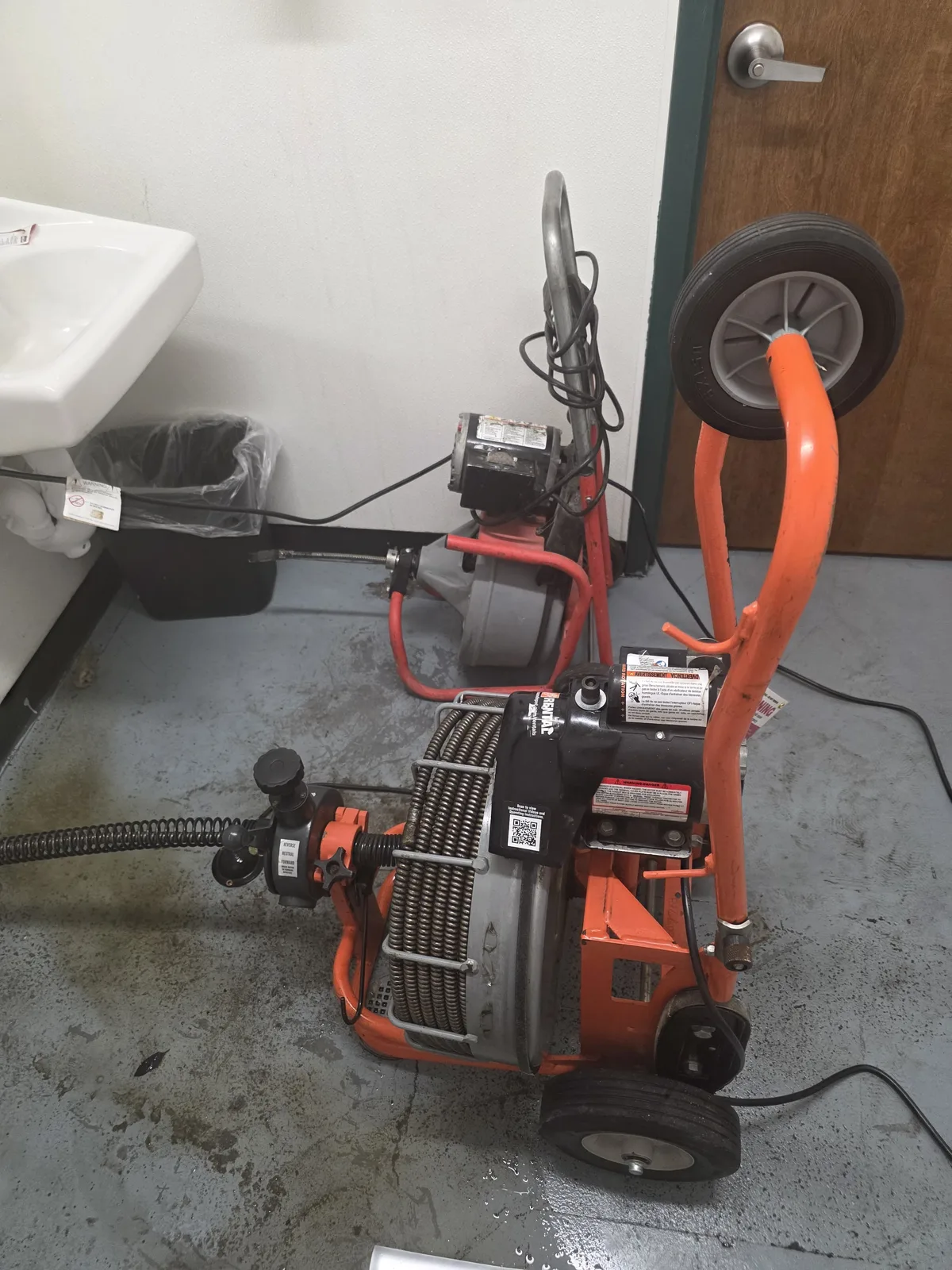 Drain cleaning machine set up at a commercial floor drain